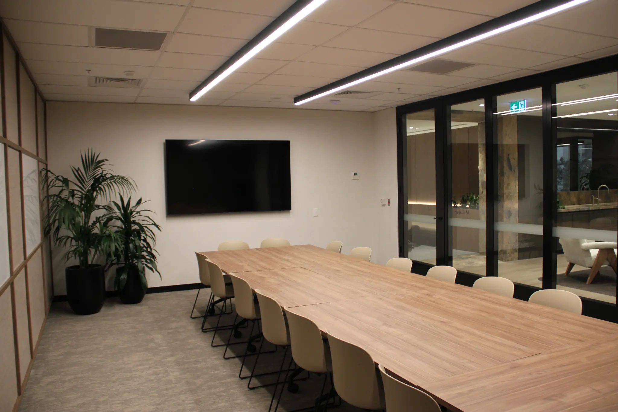 Meeting room connected visually to the business lounge through black-framed glazing