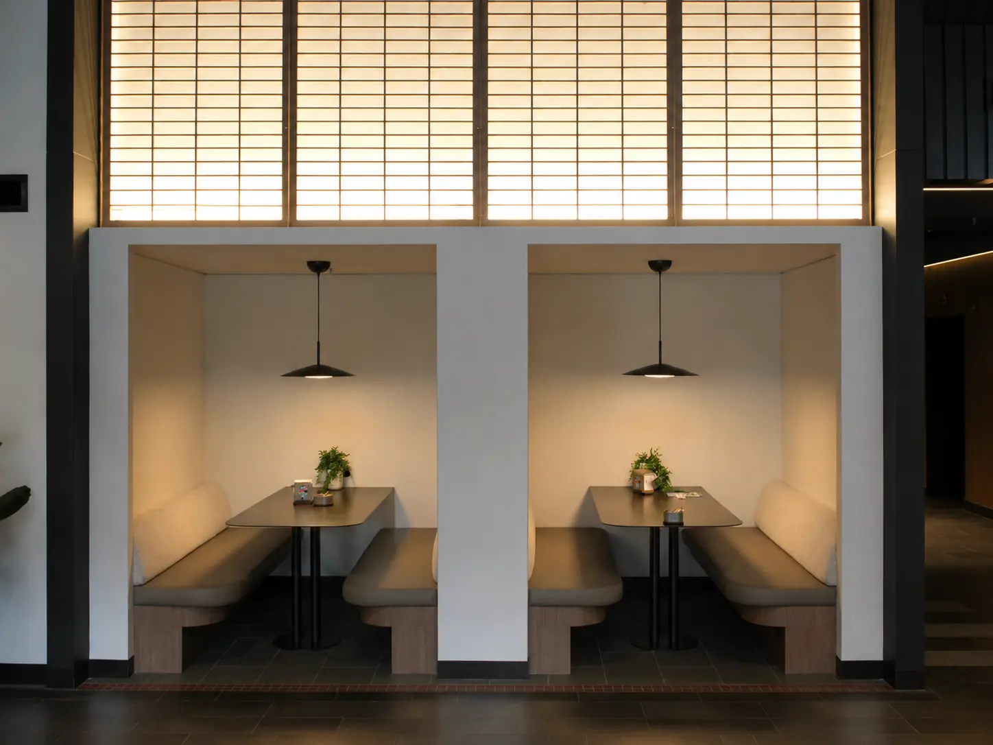 Square-on view of the private meeting booths beneath a backlit screen